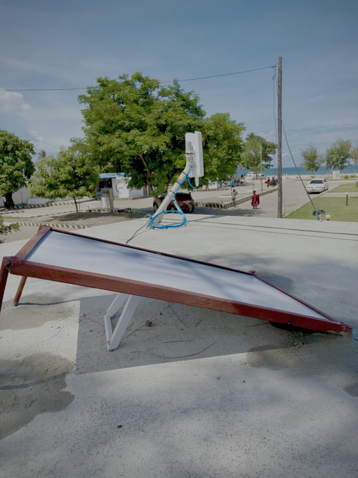 Starlink terminal on a roof frame mount, with the road and coast behind